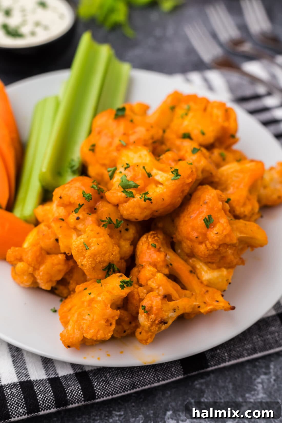 Crispy Buffalo Cauliflower Wings on a white plate, garnished with fresh parsley.
