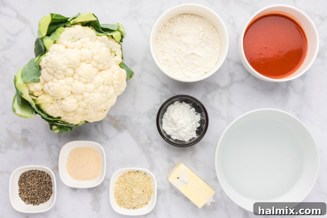 A spread of ingredients laid out on a kitchen counter for making Buffalo Cauliflower.