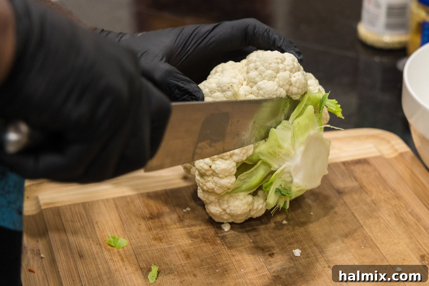 Slicing a head of cauliflower with a chef's knife into florets.