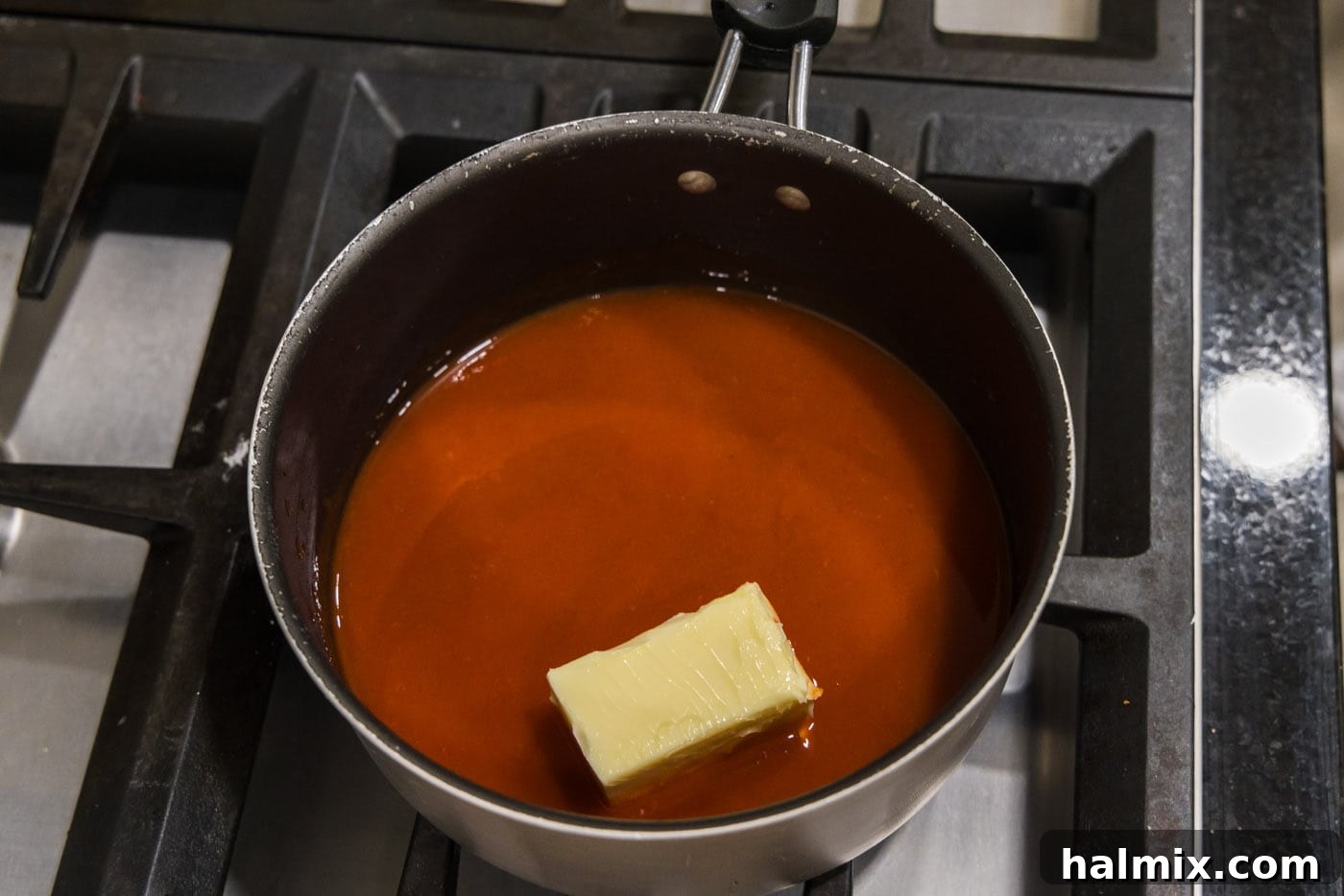 Butter and hot sauce simmering together in a saucepan.