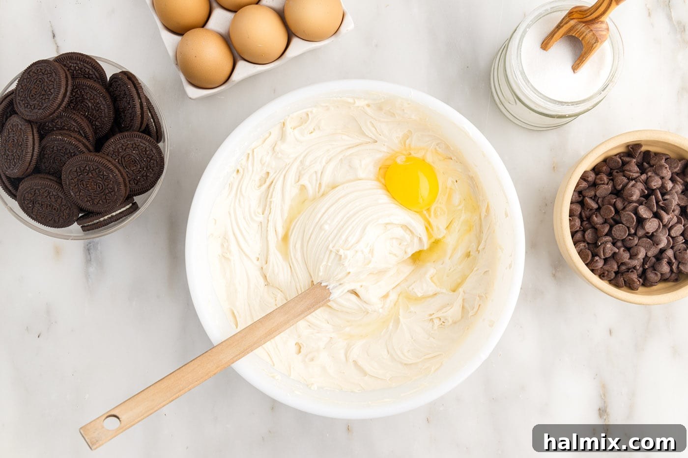 adding an egg to cheesecake batter