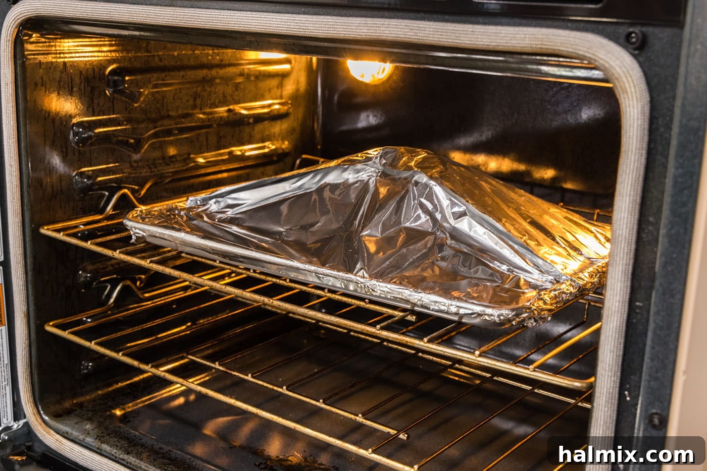 Roasted Leg of Lamb 8 The foil-wrapped leg of lamb roasting in the oven, with the foil creating a steamy environment for tender results.