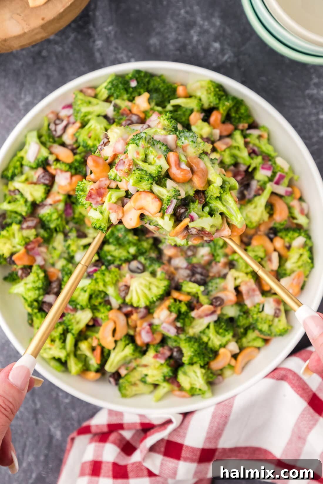 Crunchy Broccoli Cashew Delight 10 Two spoons holding up Broccoli Cashew Salad from a bowl