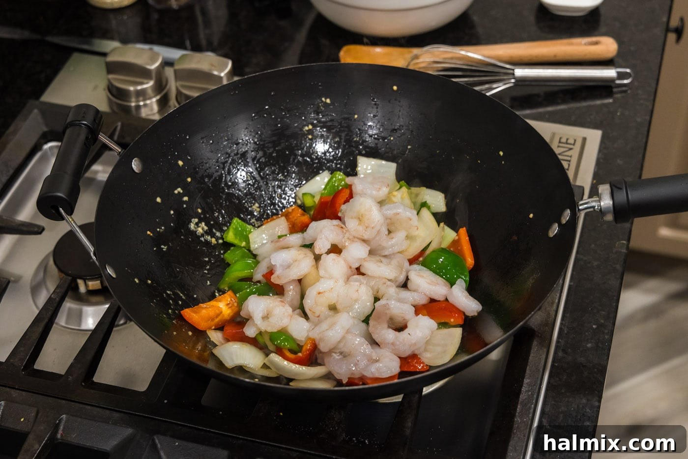adding shrimp to wok with vegetables