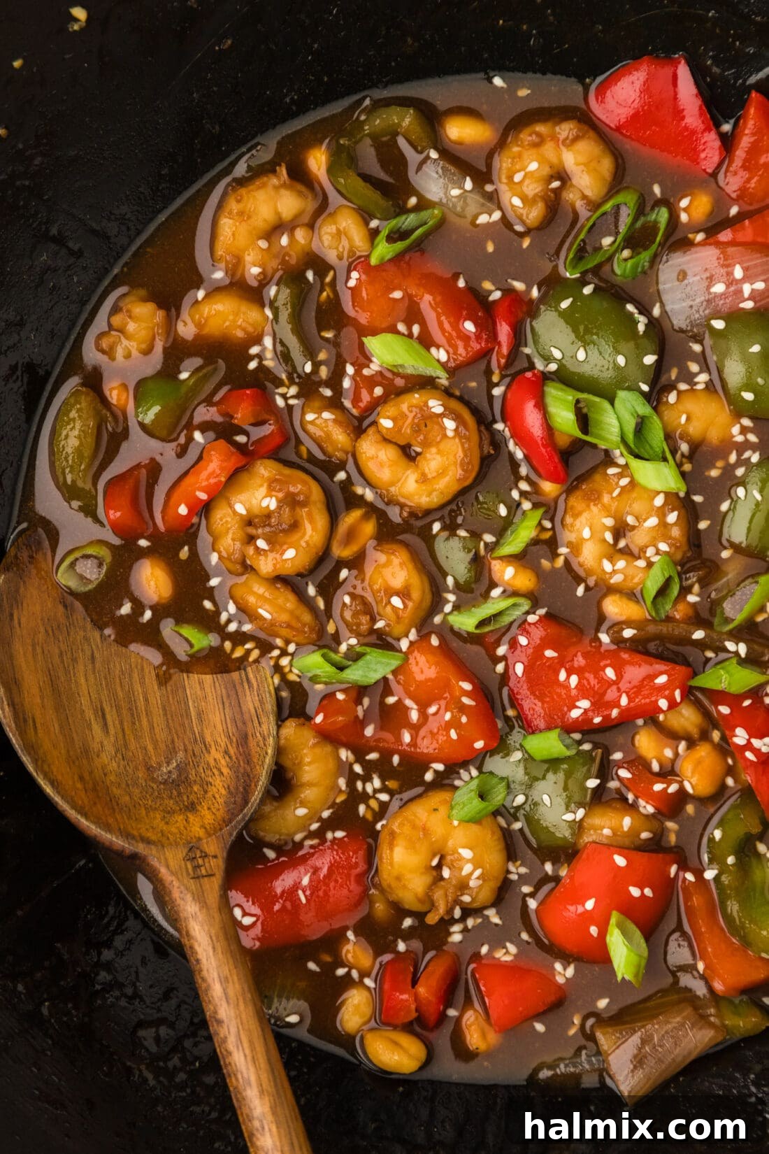 Close up photo of a wok of Kung Pao Shrimp with a spoon in it