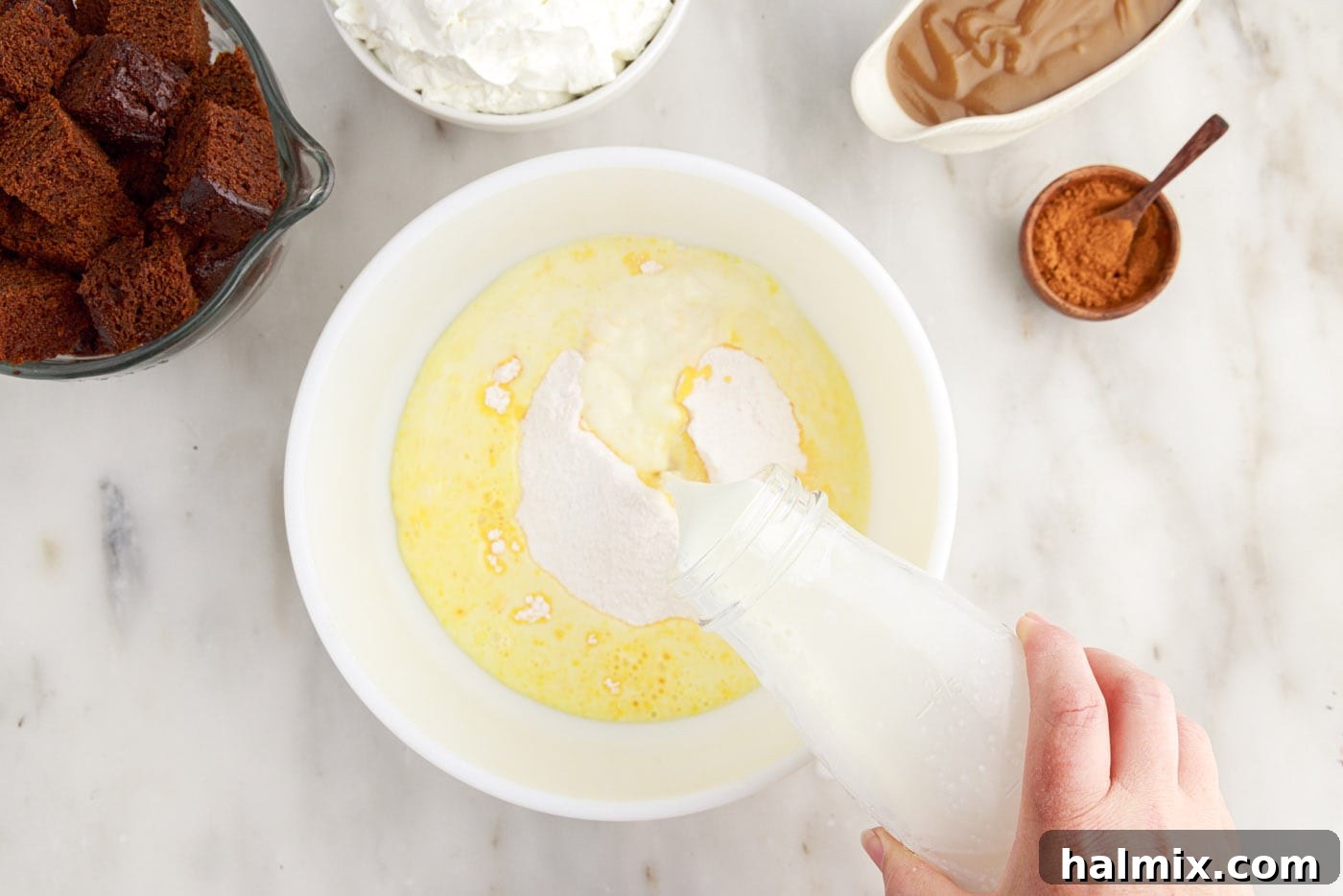 Pouring instant pudding mix into a bowl of milk