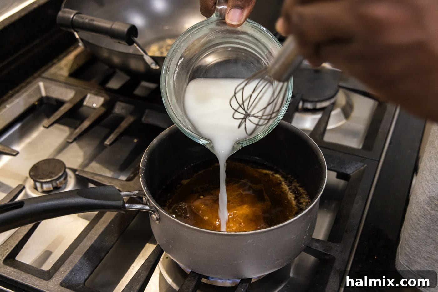 pouring cornstarch slurry to stir fry sauce in pan