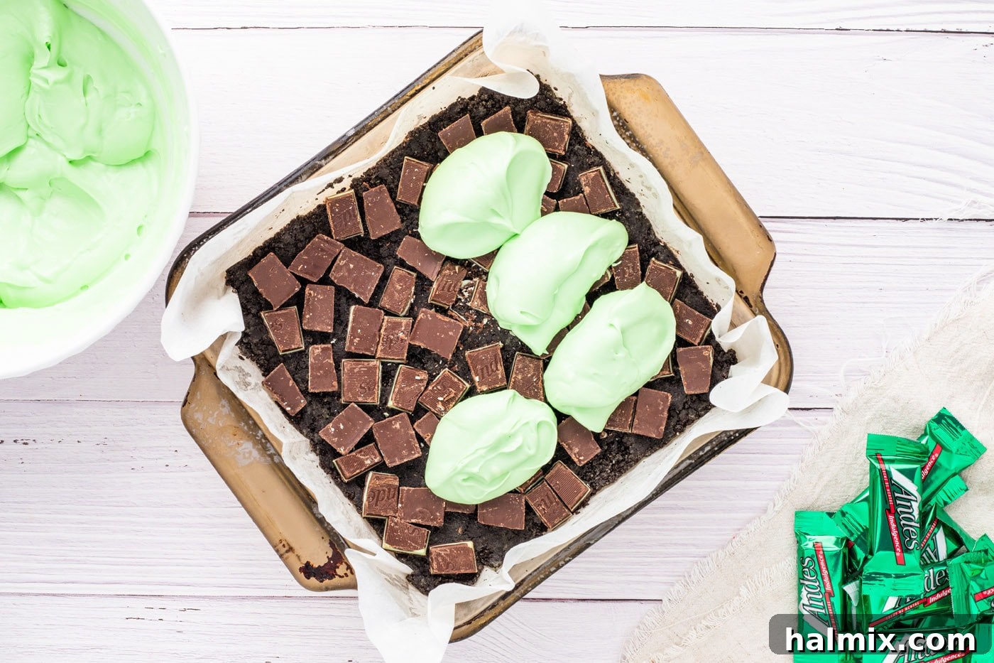 Spreading dollops of peppermint cream cheese over the Oreo crust and Andes mints.