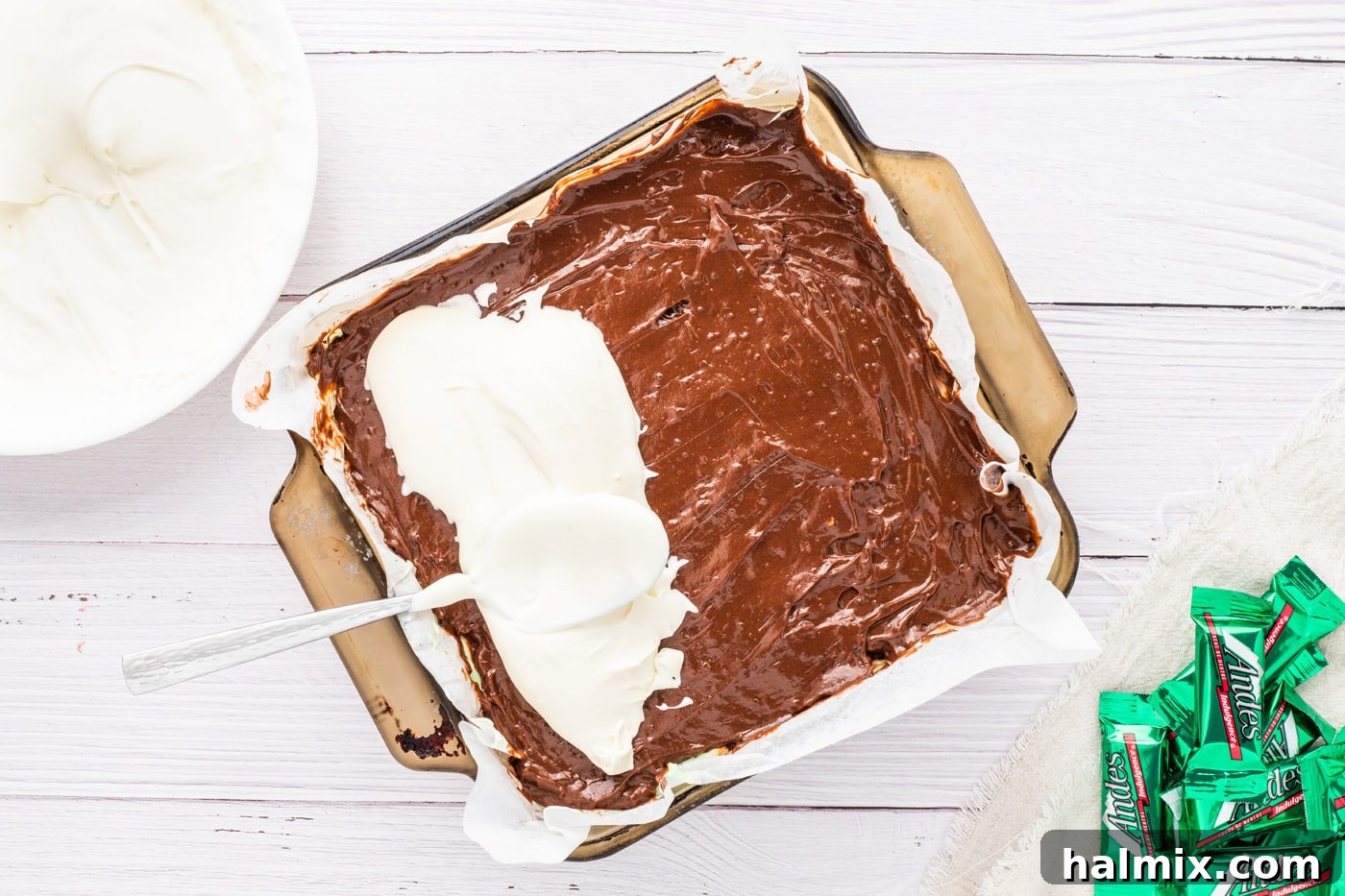 Spreading thickened whipped cream over the chocolate pudding layer for the top.