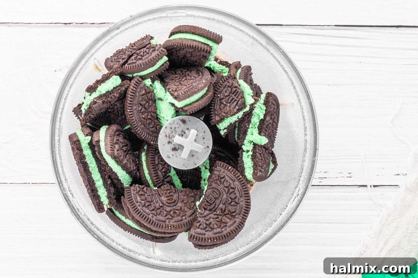 Mint Oreo cookies being processed into fine crumbs in a food processor.