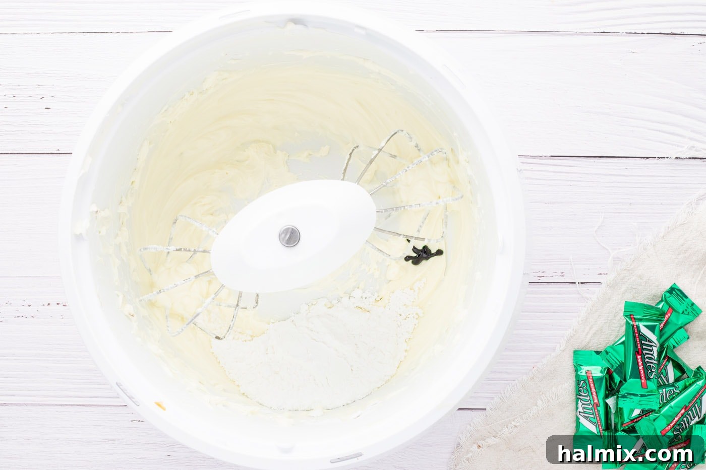 Green food coloring being mixed into the peppermint cream cheese mixture.