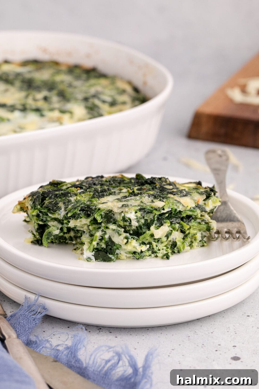 A close-up of a serving of golden-brown Spinach Souffle on a white plate, ready to be enjoyed.