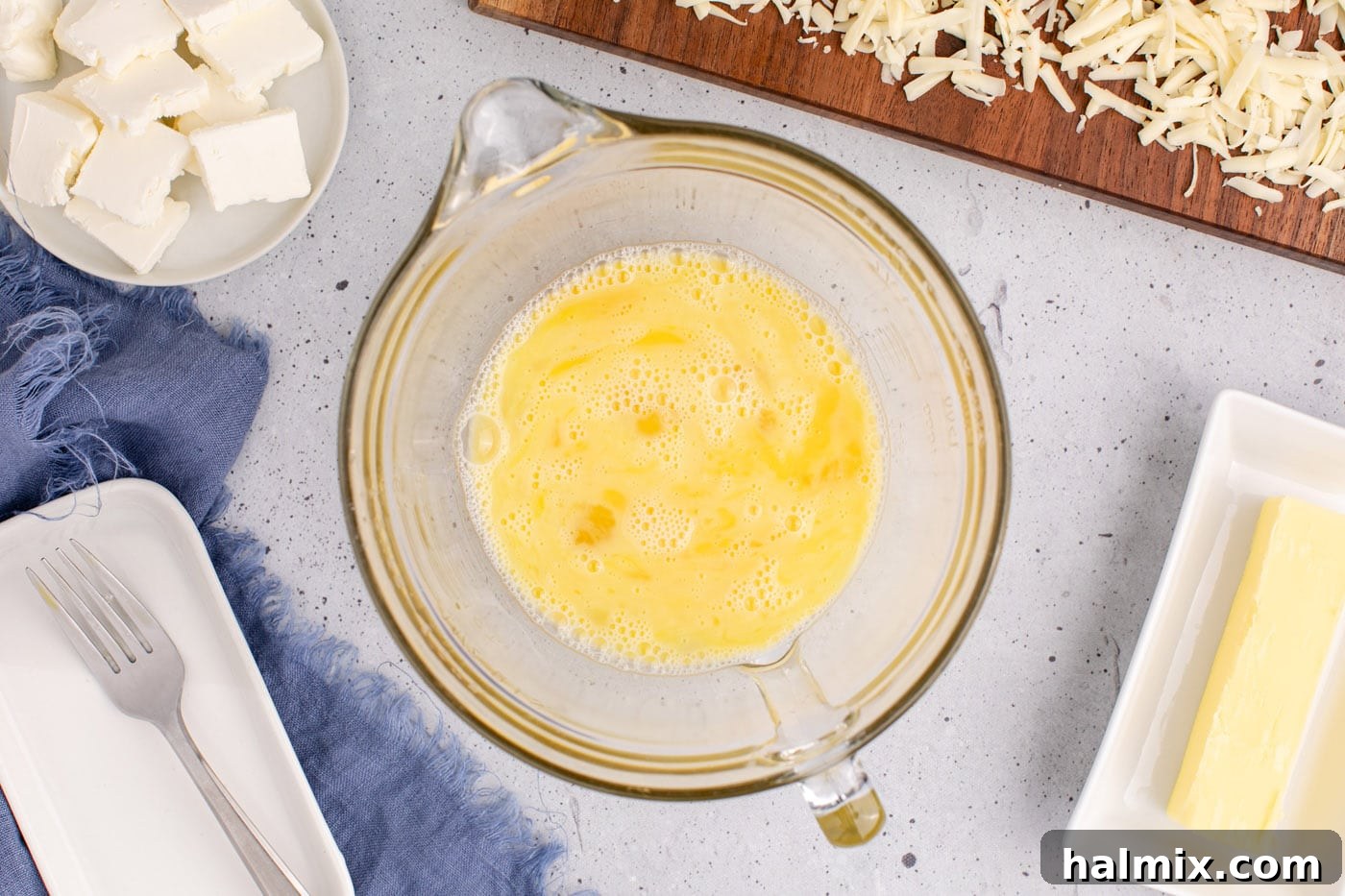 Whisked eggs in a bowl, showing a smooth, yellow consistency ready for mixing.