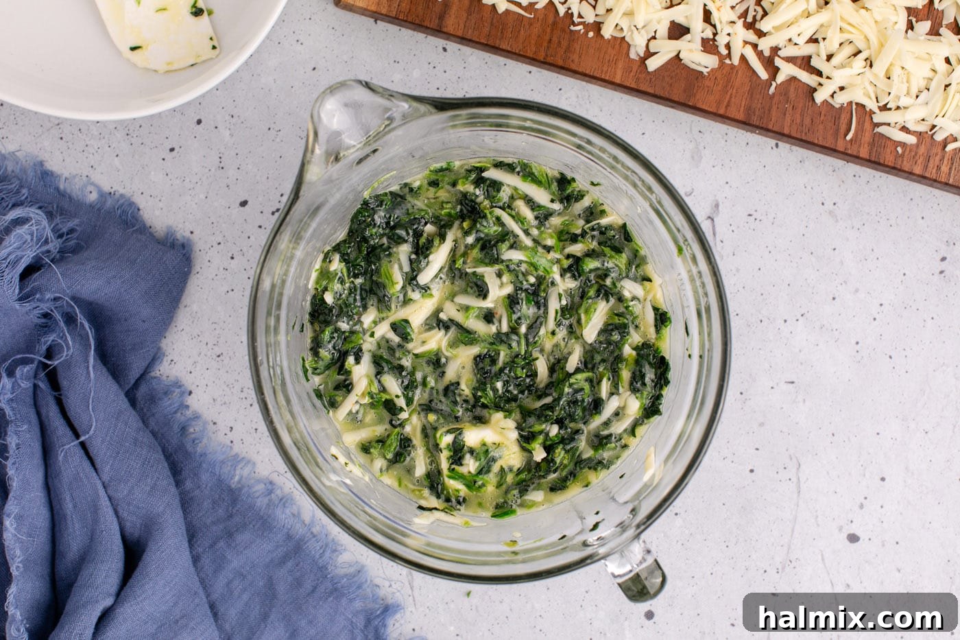 The full spinach souffle mixture transferred to a casserole dish, ready for baking, with a smooth, even surface.