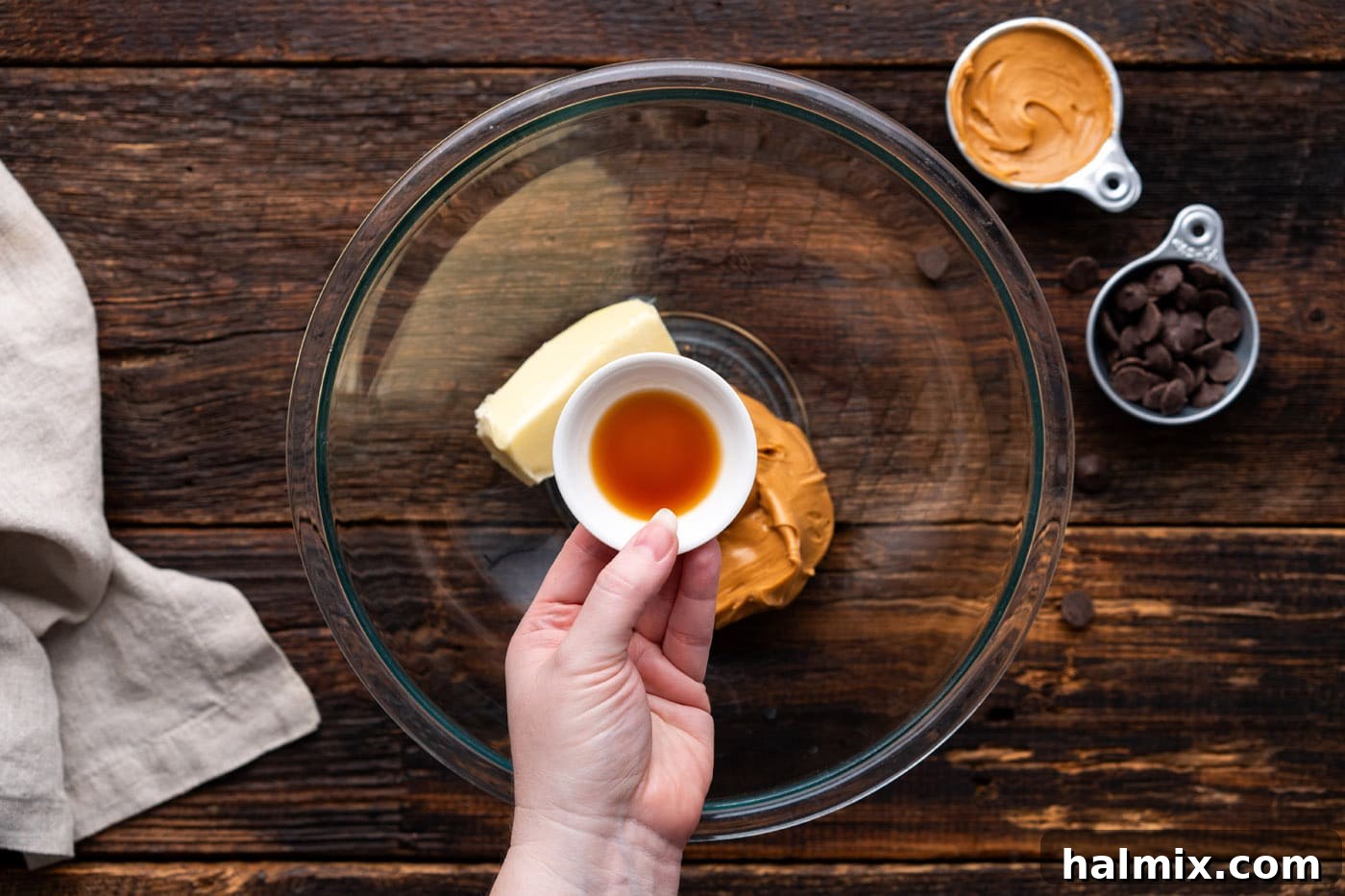 adding vanilla to bowl of peanut butter and butter