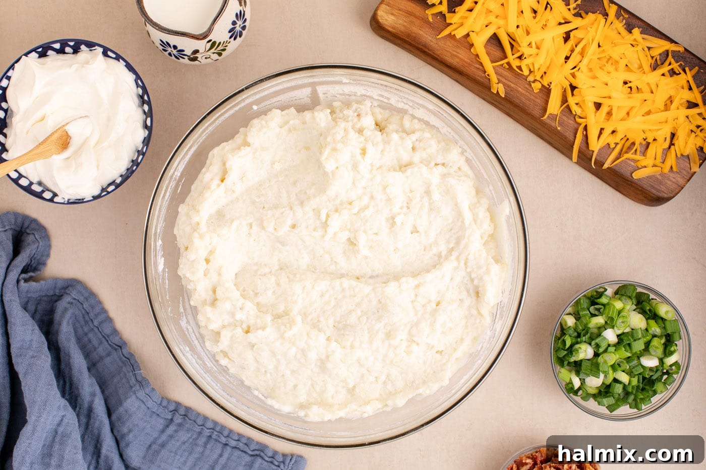 Decadent Twice Baked Potato Casserole 8 The creamy, seasoned twice baked potato filling expertly mixed in a bowl, showing a smooth and rich texture.
