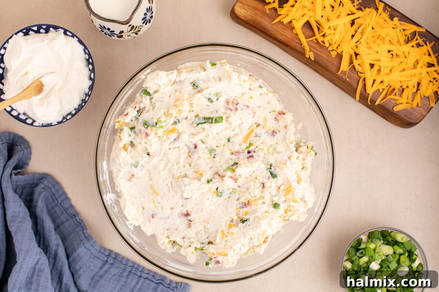 Decadent Twice Baked Potato Casserole 10 The fully combined twice baked potato casserole filling, rich with cheese, bacon, and green onions, in a mixing bowl.
