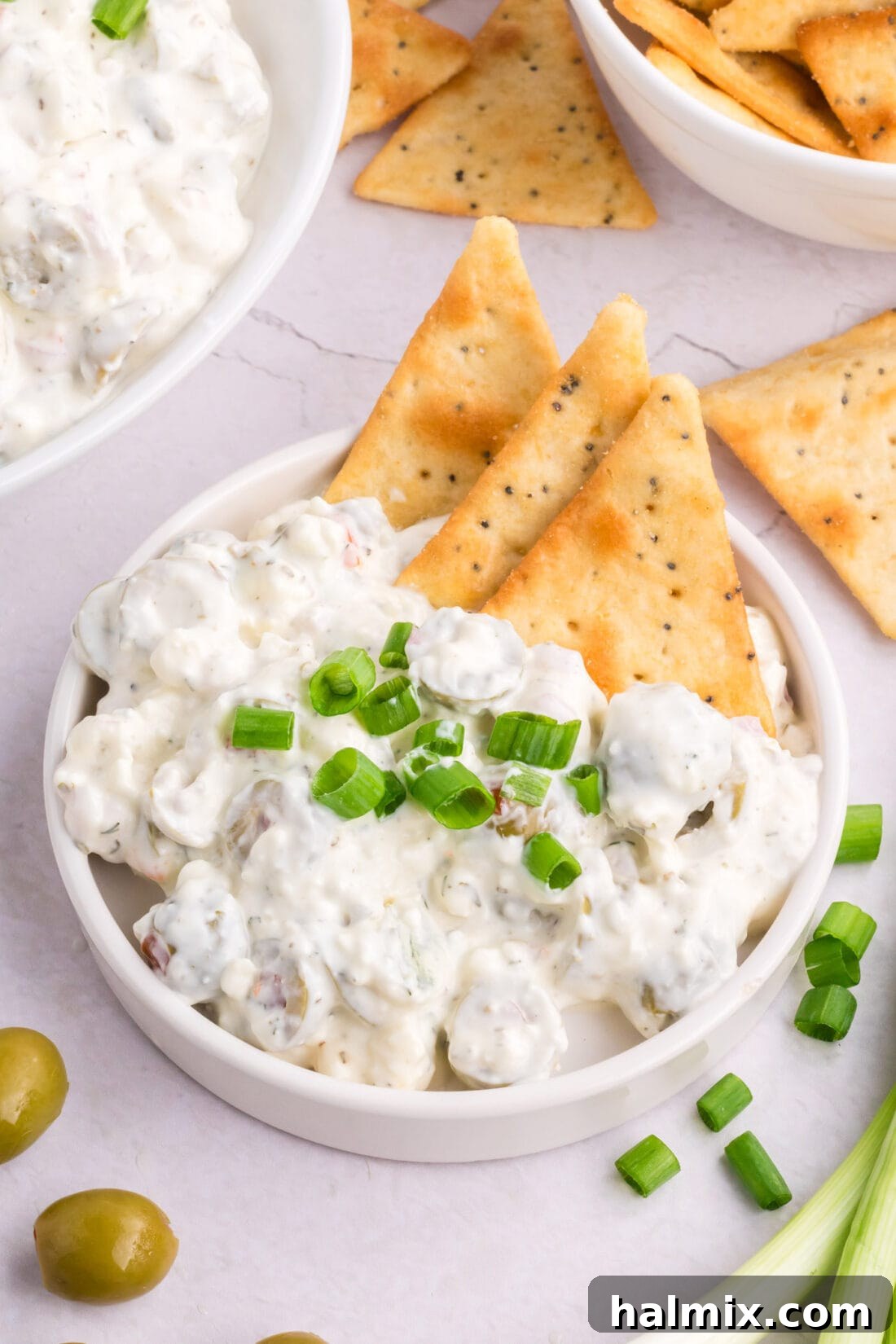 Dirty Martini Dip on a plate with crackers, ready to be served