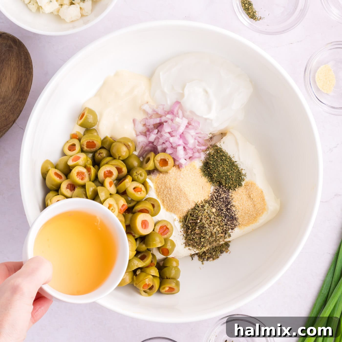 adding olive bring to sliced olives, seasonings, shallot, and cream cheese in a bowl