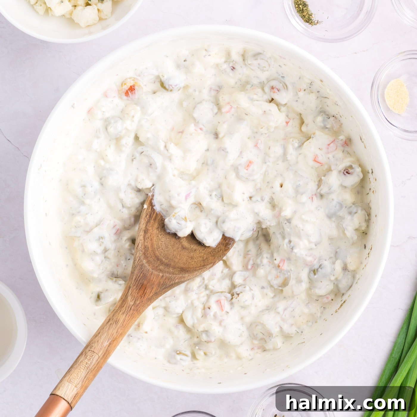 wooden spoon mixing dirty martini dip