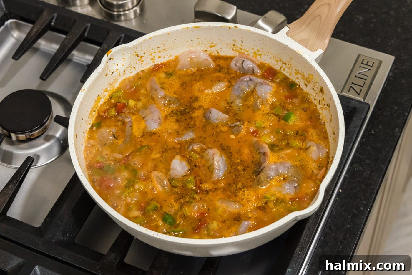 Spicy Shrimp Creole 12 Raw shrimp being stirred into the rich tomato-based creole sauce, ready for its final cook.