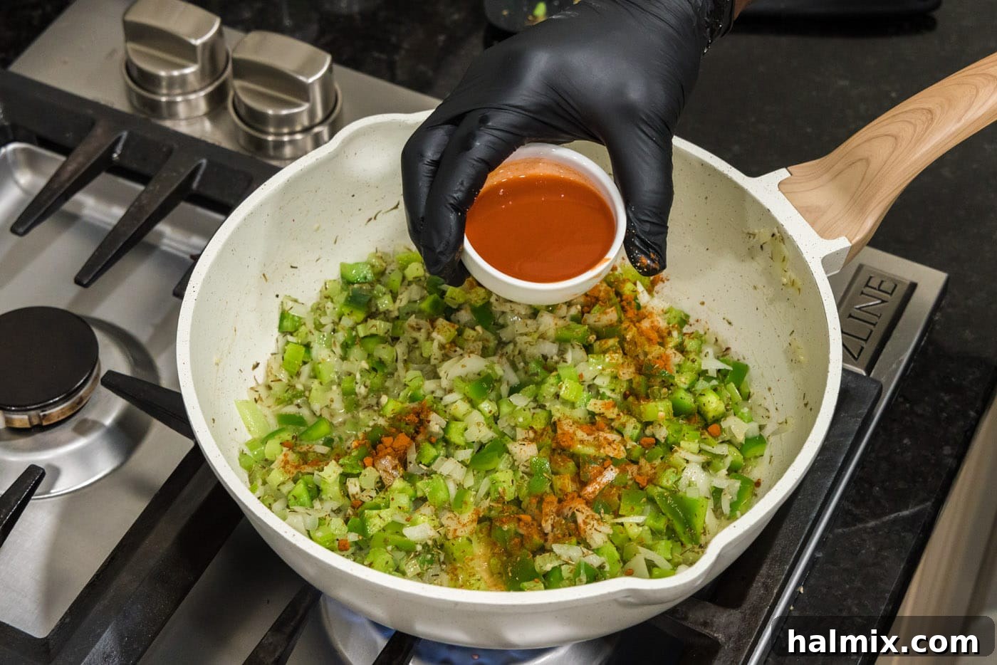 Spicy Shrimp Creole 7 Pouring hot sauce and cayenne pepper into the skillet with the seasoned vegetables.