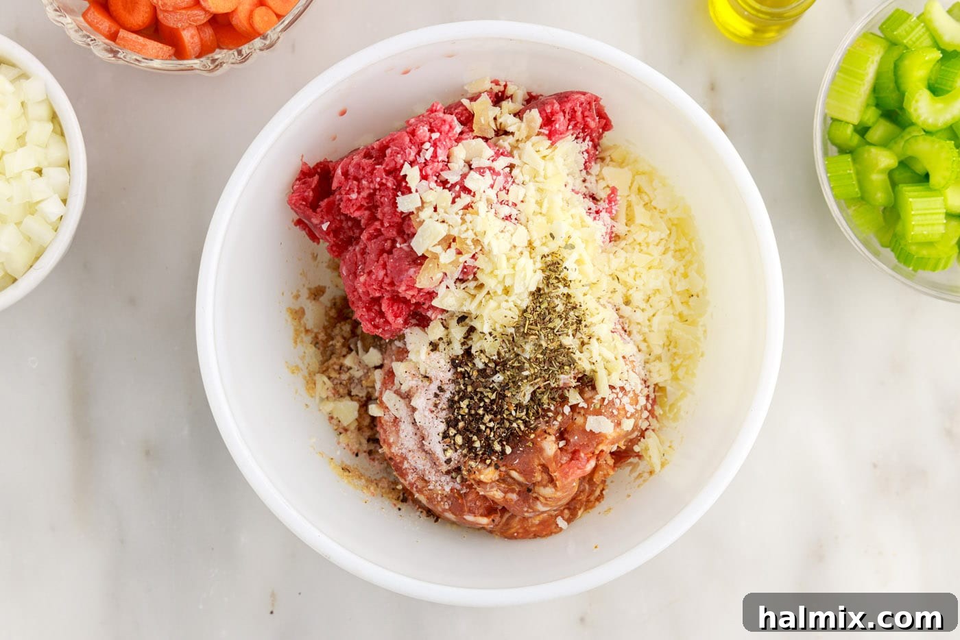 ground beef, seasoning, sausage, and bread crumb mixture in bowl