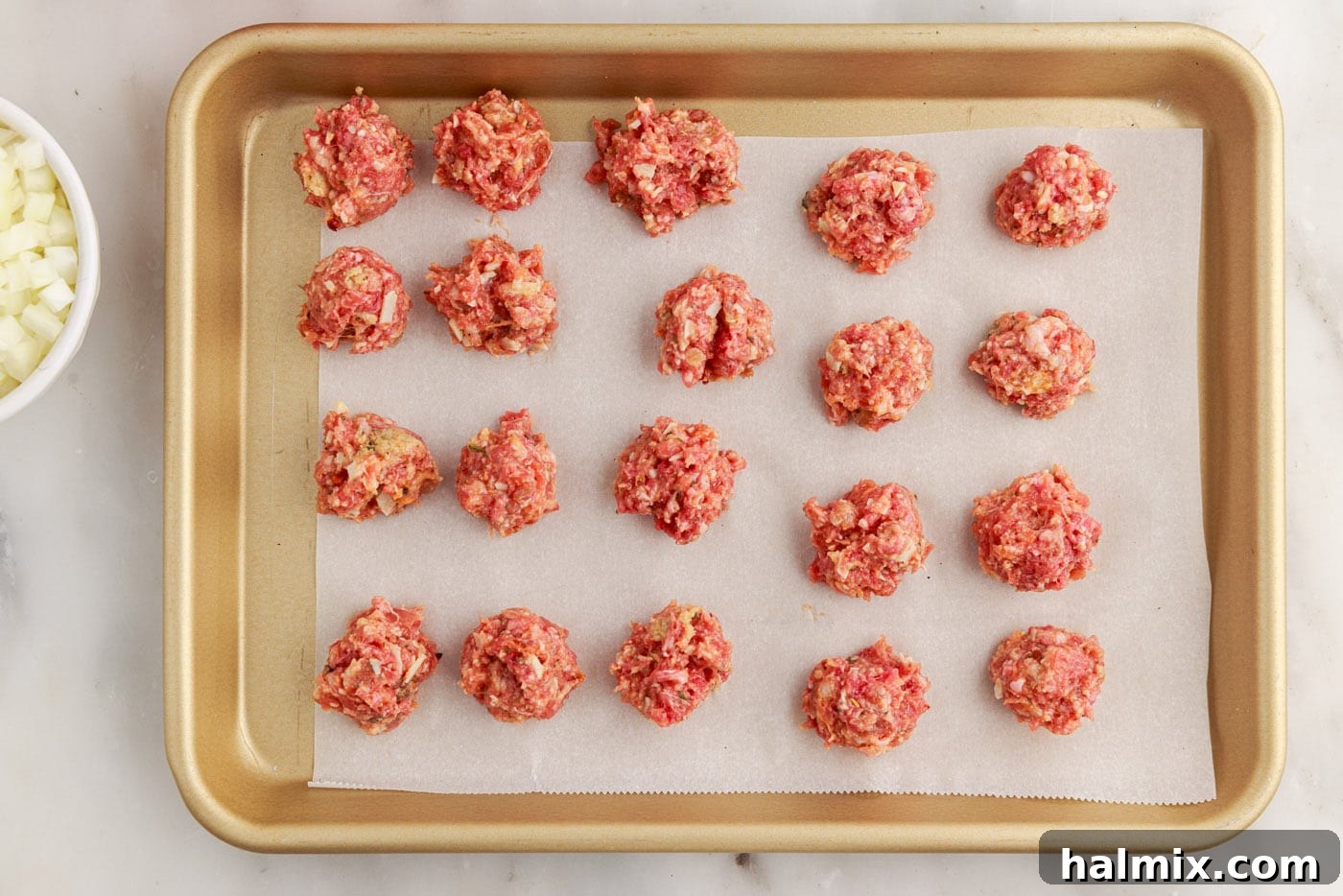 Italian sausage and ground beef meatballs on a baking sheet