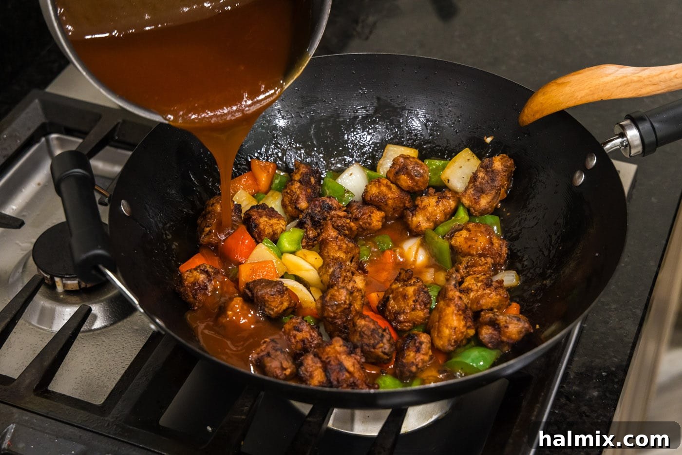 Golden Fried Pork with Tangy Glaze 16 pouring sweet and sour sauce over chicken and stir fried veggies