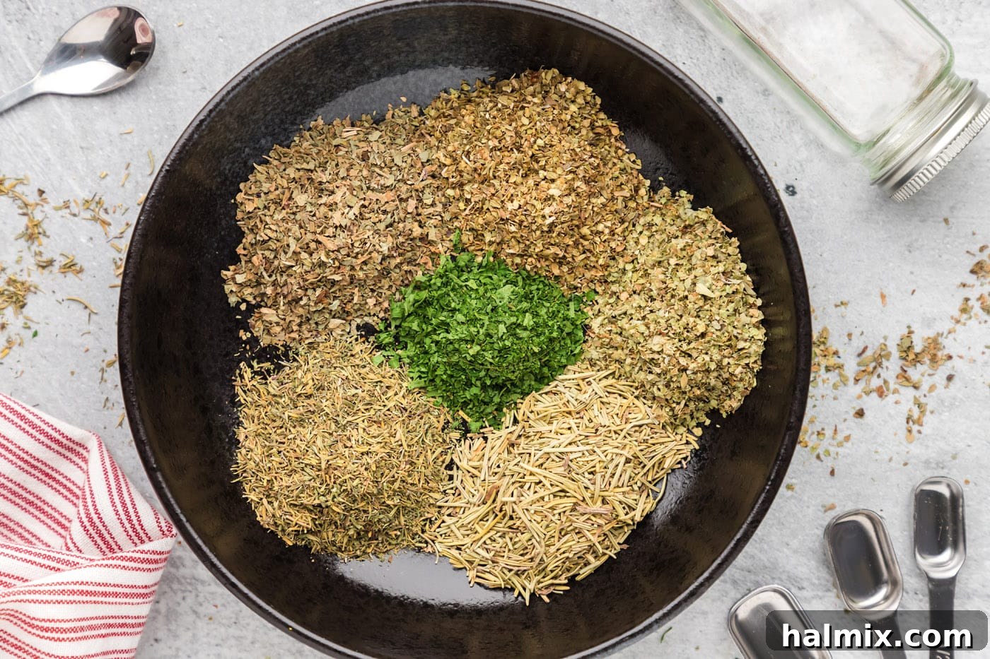 dried herbs being combined in a bowl