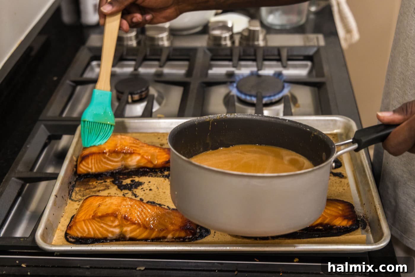 Basting baked salmon fillets with the rich, thickened miso glaze for a caramelized finish.