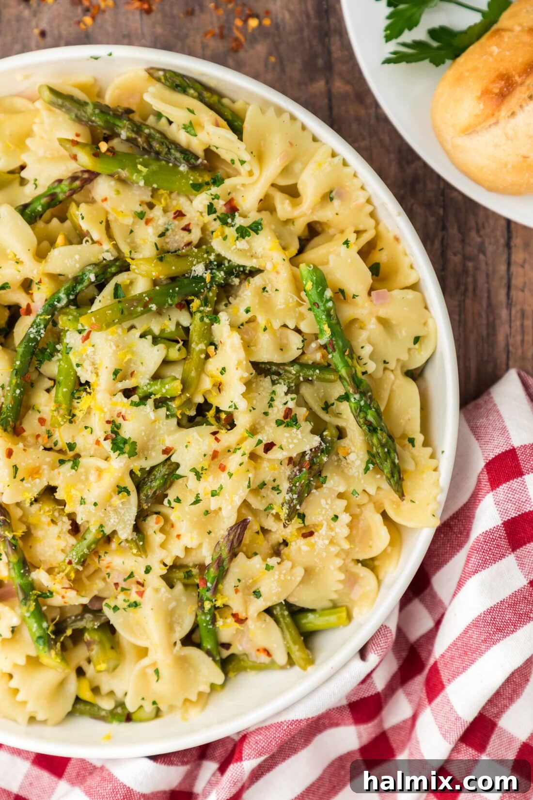 Close-up view of a half-filled bowl of Asparagus Pasta, highlighting the fresh asparagus, pasta, and the creamy, luscious sauce.