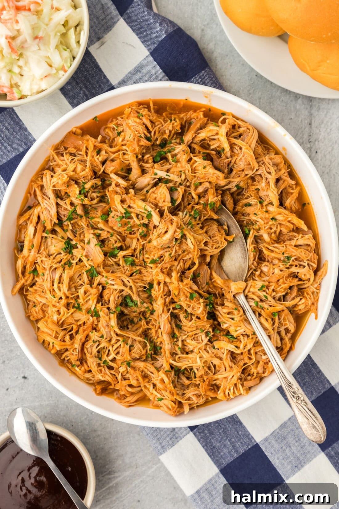 An overhead photo of Instant Pot BBQ Chicken, beautifully plated and ready to be served, with a spoon for scooping.