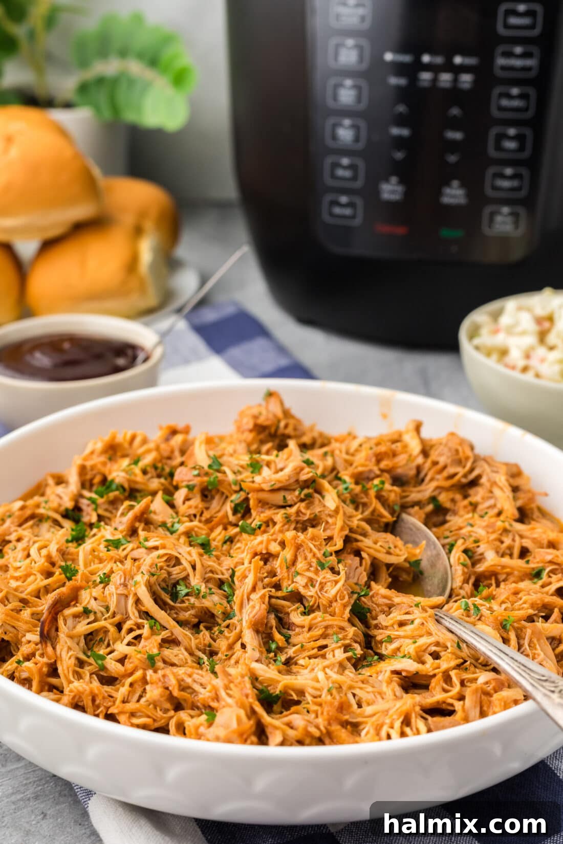 Instant Pot BBQ Chicken served in a bowl with a spoon, ready to be enjoyed.