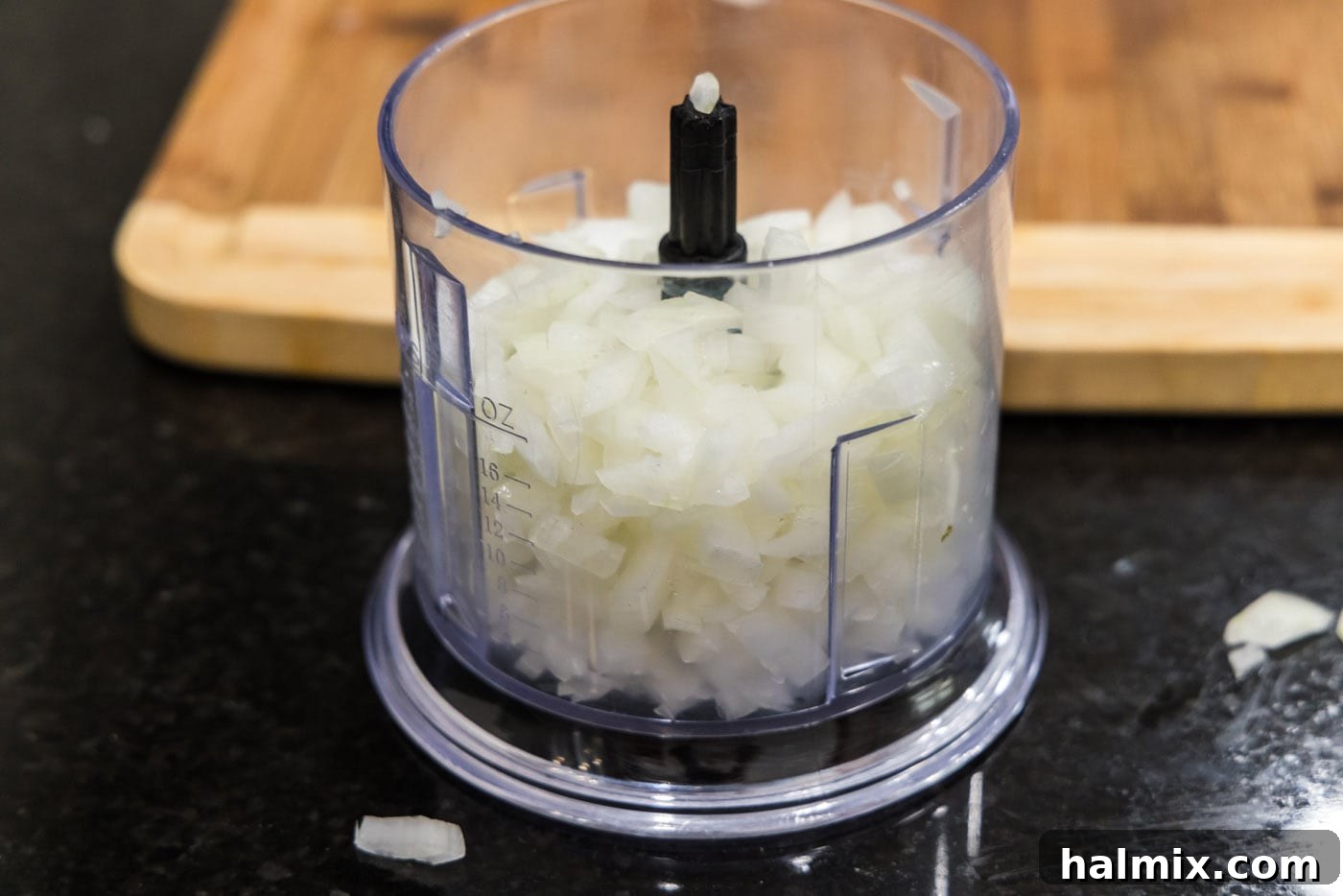 Coarsely chopped onion pieces in a food processor, ready for mincing.
