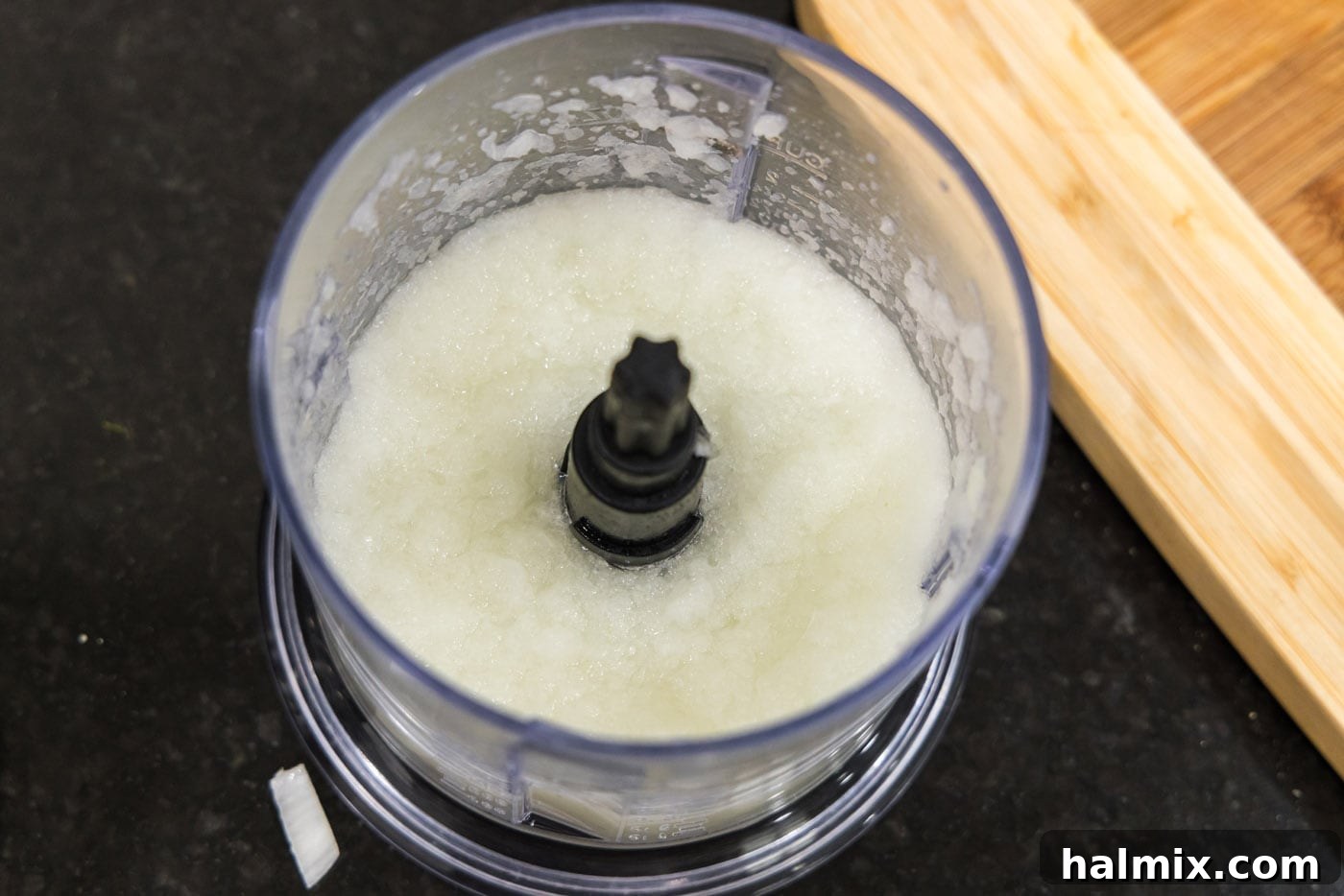 Finely minced onion in a food processor, demonstrating the desired consistency.