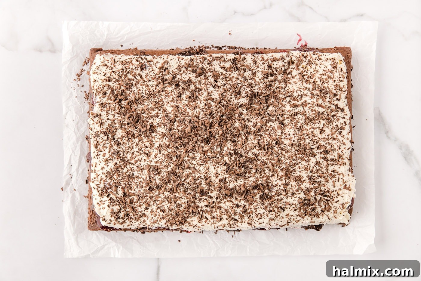 Decadent Black Forest Poke Cake 11 chocolate shavings on top of whipped cream over black forest poke cake