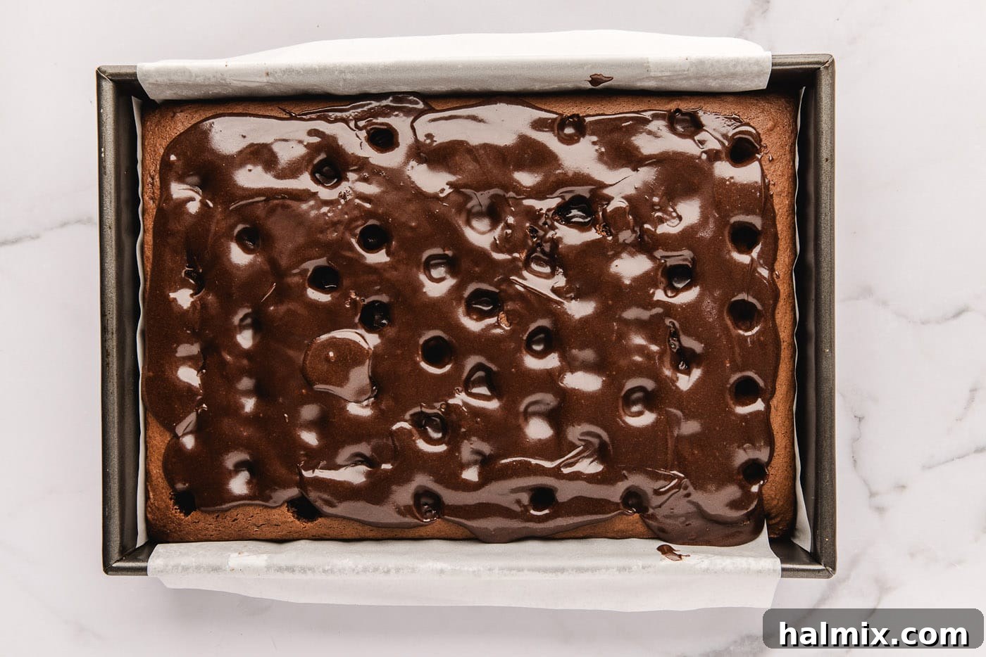 Decadent Black Forest Poke Cake 7 fudge sauce poured over holes in chocolate cake