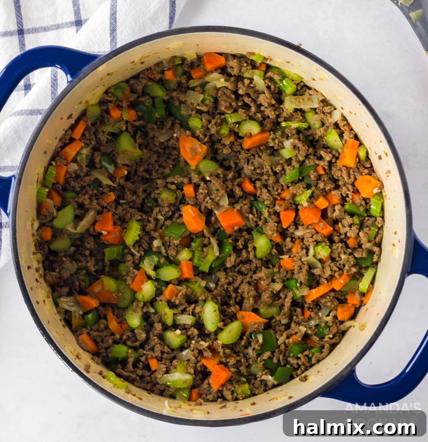 Ground beef, celery, carrot, onion, green bell pepper and garlic in a pot