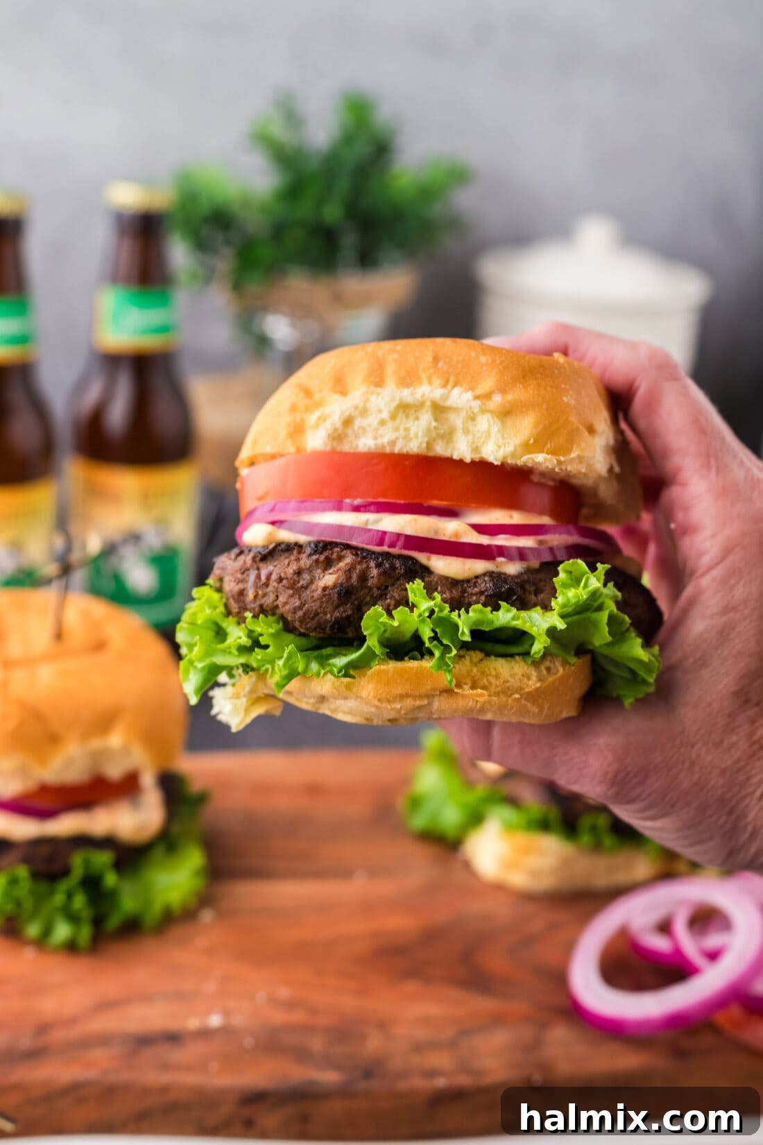 Mighty Buffalo Burger 12 A hand presenting a mouth-watering Buffalo Burger on a bun with fresh toppings, ready to be enjoyed.