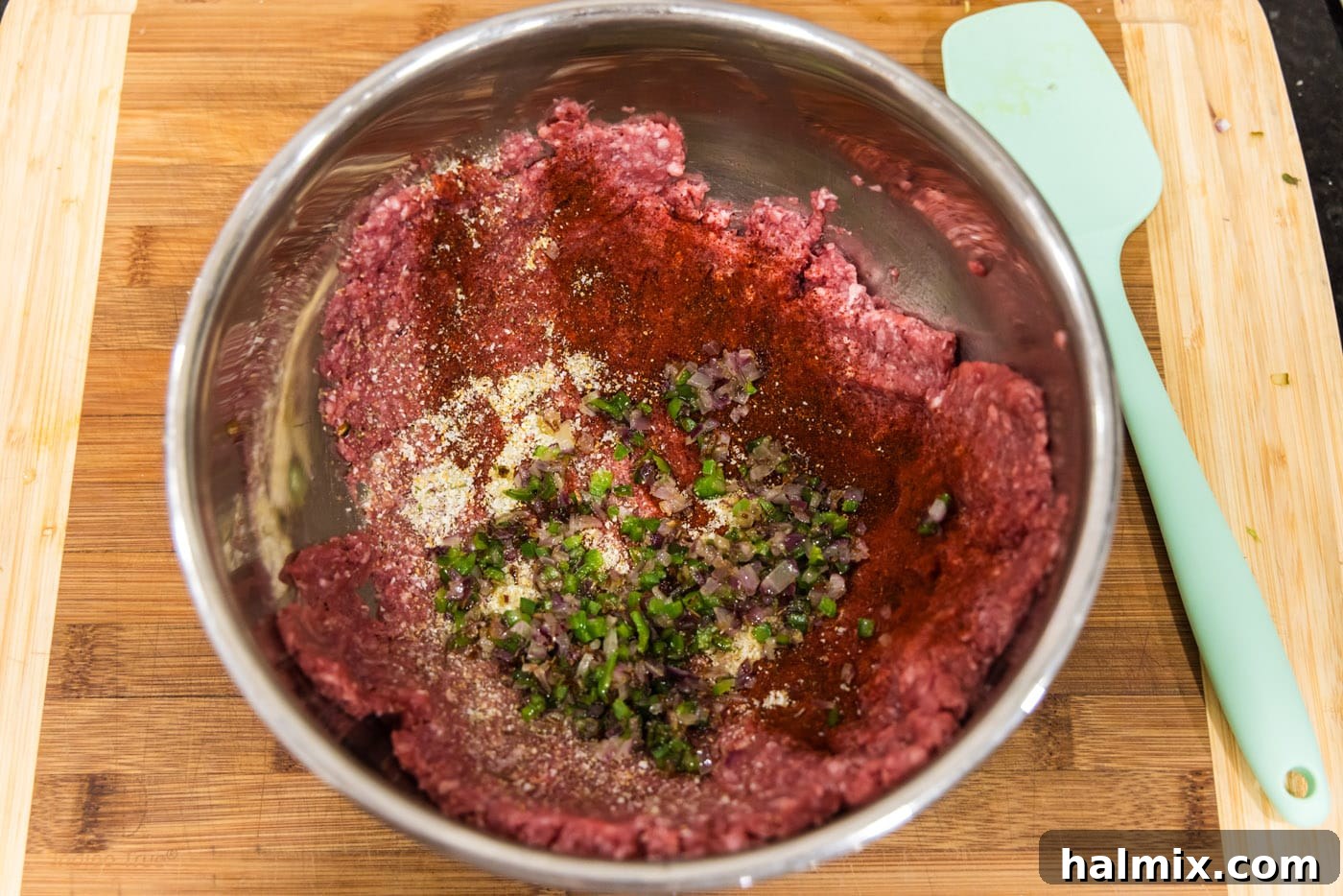 Mighty Buffalo Burger 7 Ground bison in a mixing bowl with the sautéed onions and jalapenos added, prior to mixing.