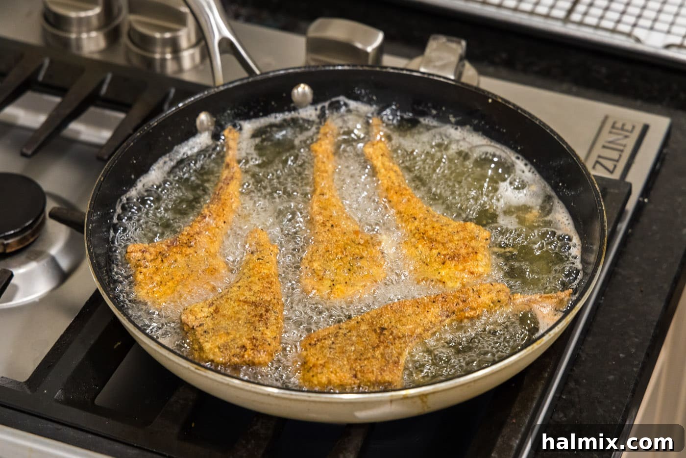 Golden Fried Lamb Perfection 12 fried lamb chops in a skillet of oil