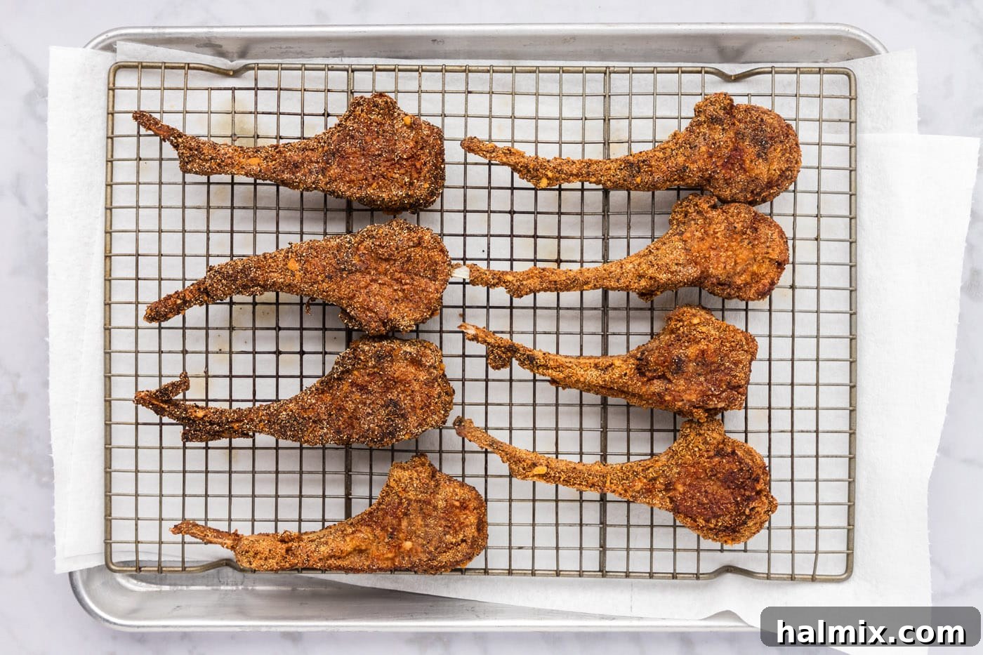 Golden Fried Lamb Perfection 13 golden crusted fried lamb chops on a wire rack