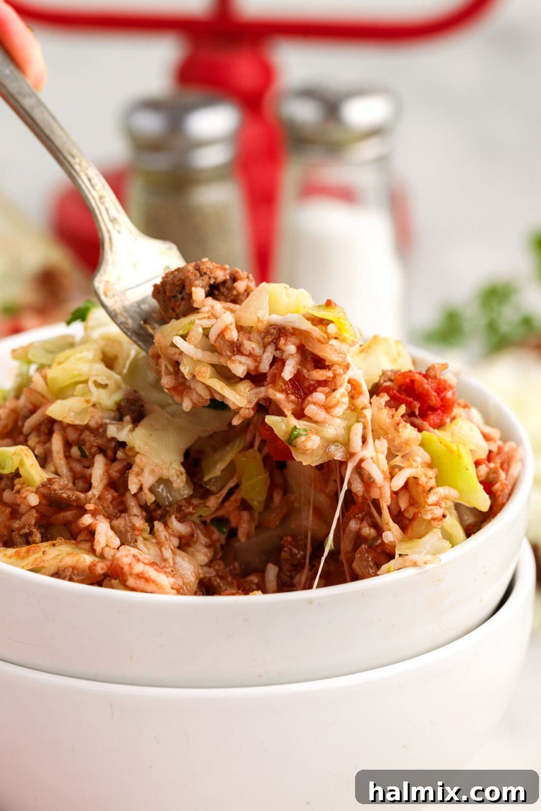 Hearty Unstuffed Cabbage Casserole 15 Forkull of Cabbage Roll Casserole being lifted out of a bowl of Cabbage Roll Casserole