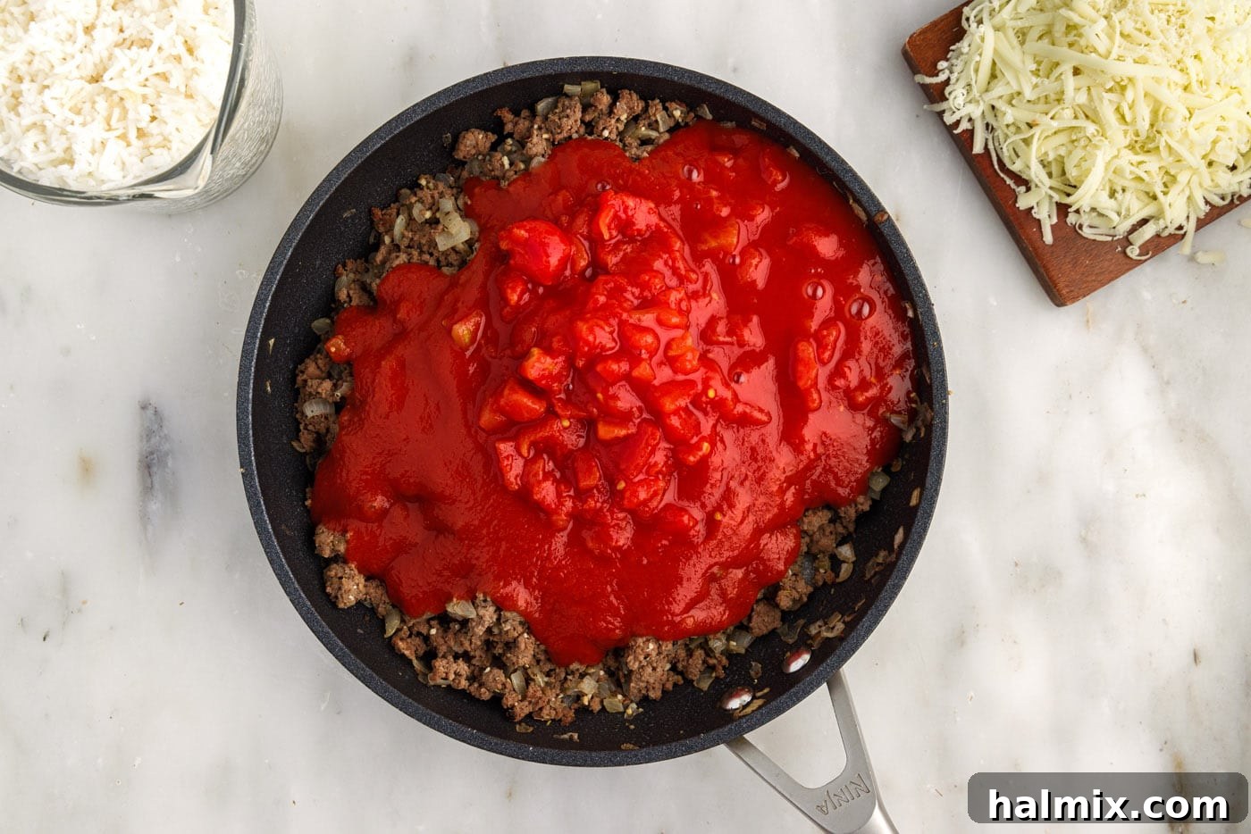 Hearty Unstuffed Cabbage Casserole 7 tomato sauce and diced tomatoes added on top of ground beef mixture in skillet