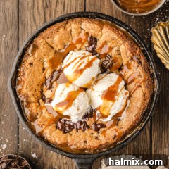 Chocolate Chip Caramel Skillet Cookie topped with ice cream and caramel