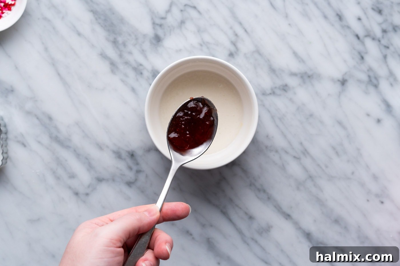spoonful of strawberry jam over top of glaze