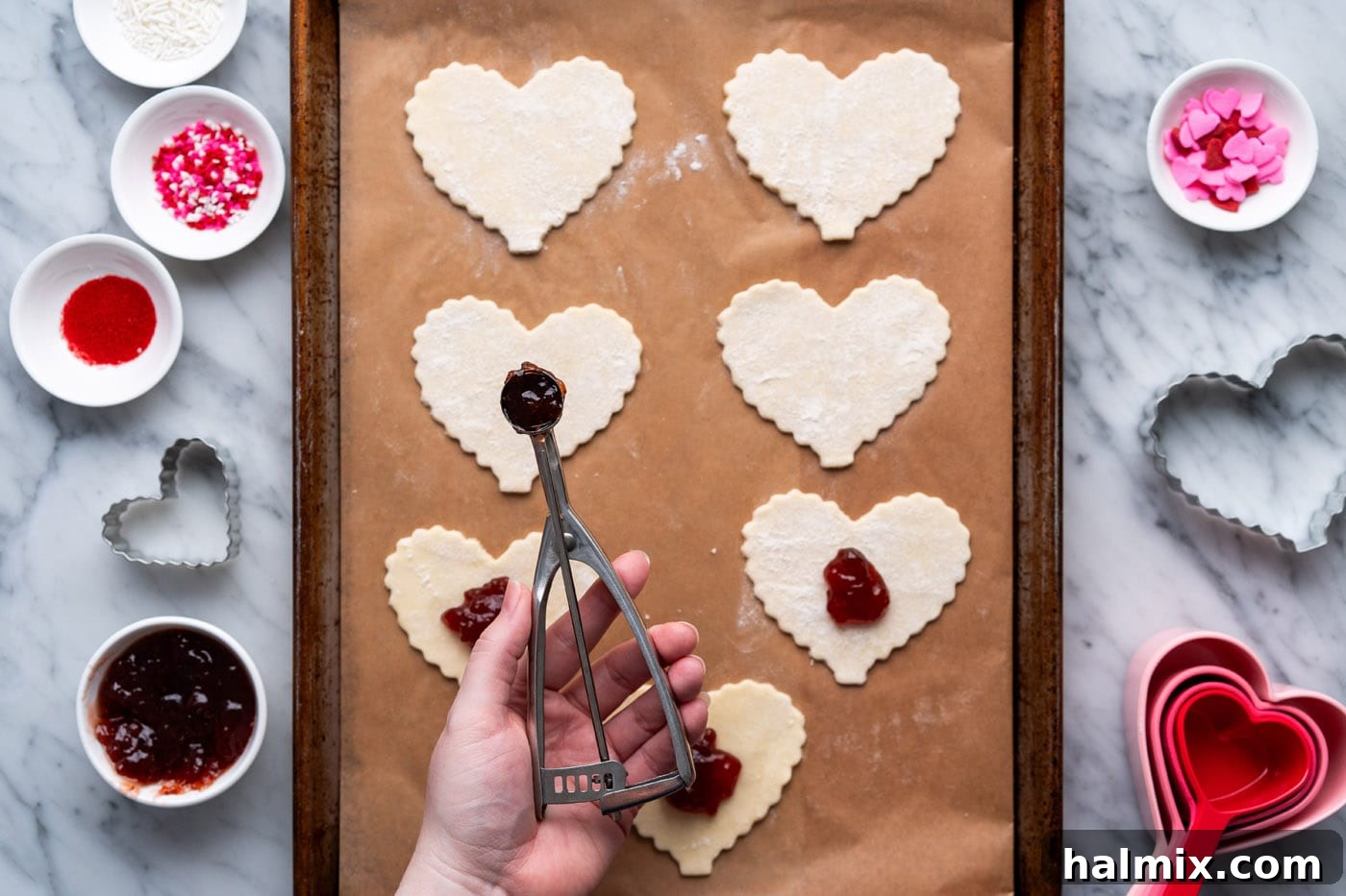 adding strawberry jam to center of heart shaped pie