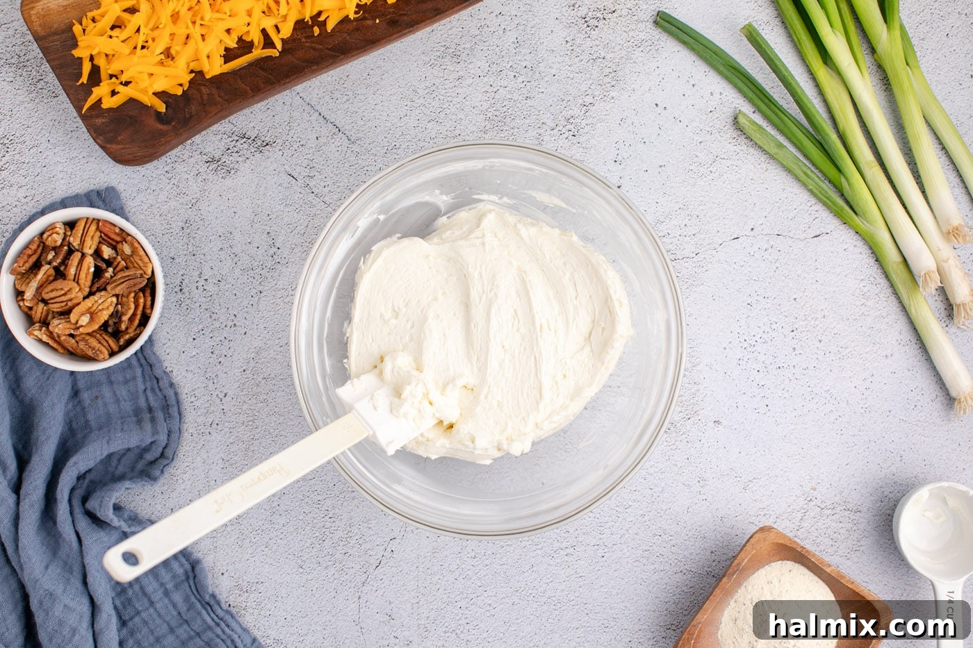 rubber spatula in a bowl of cream cheese and sour cream mixture