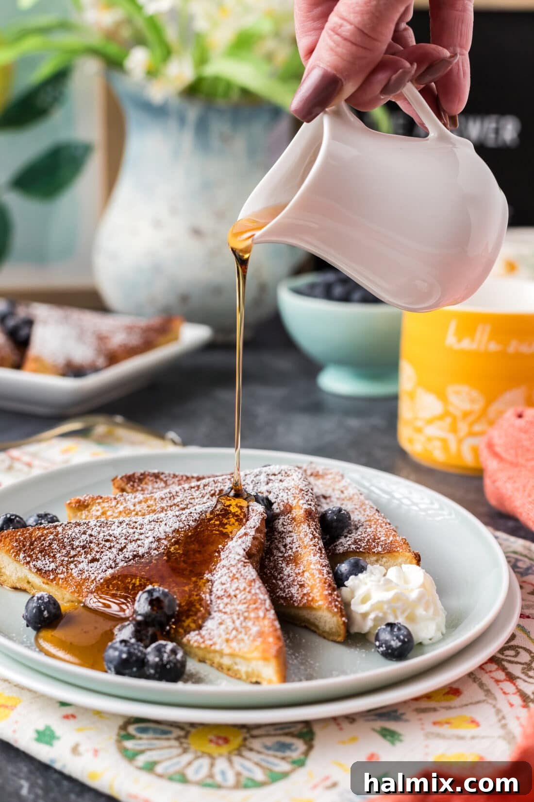 Syrup being drizzled over three slices of Air Fryer French Toast on a plate